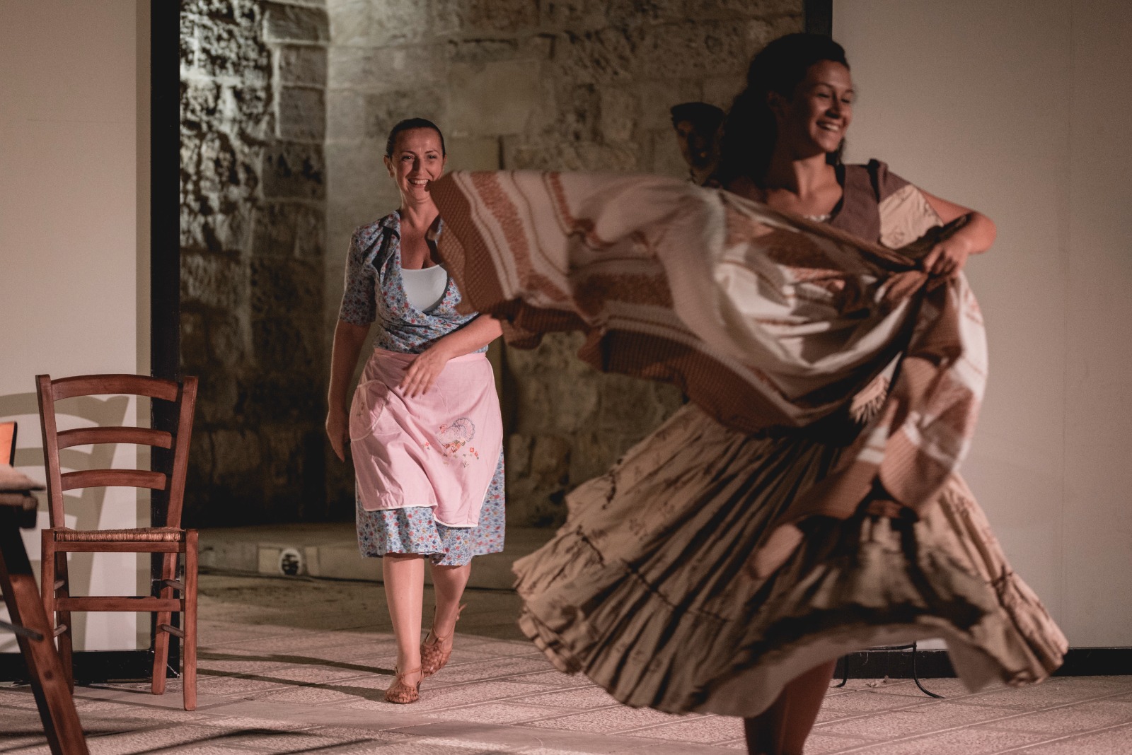 Due danzatrici in scena in un cortile in pietra